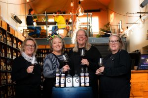 A team photograph holding wine glasses and smiling